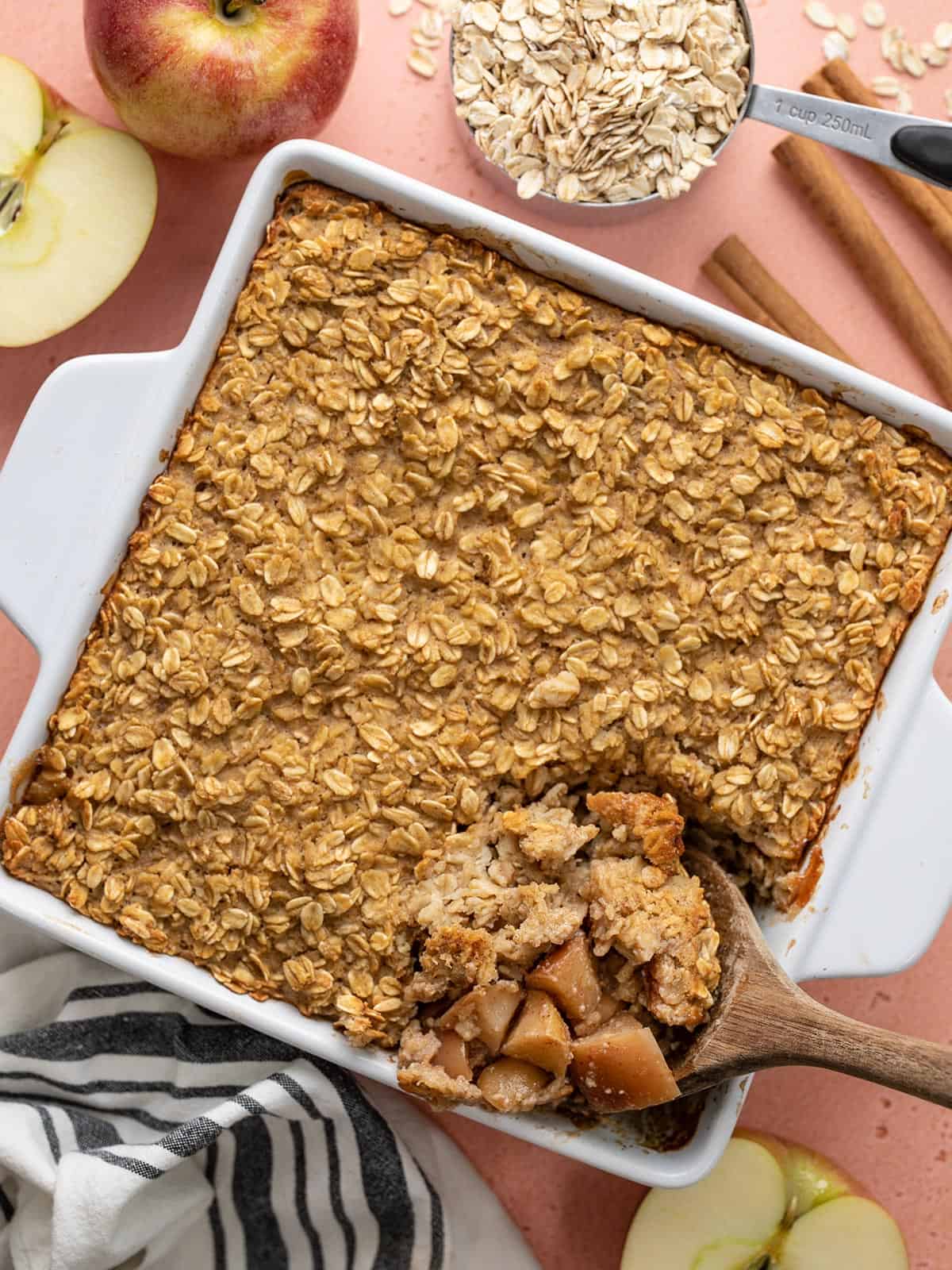 Overhead view of a casserole dish full of apple cinnamon baked oatmeal with the corner being scooped out.