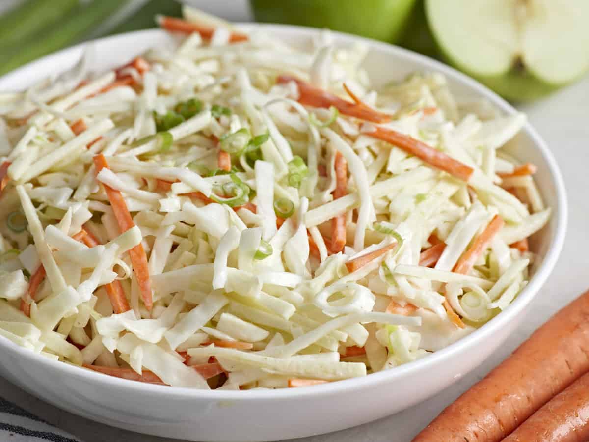 Close up side view of a bowl of apple slaw.