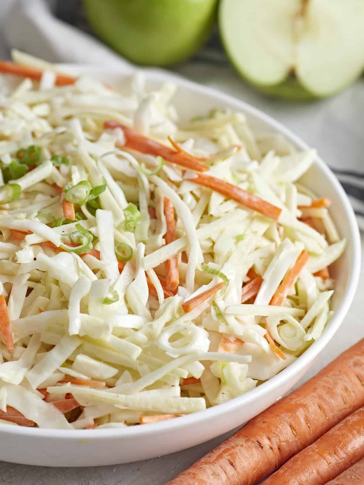 Close up side view of a bowl of apple slaw.