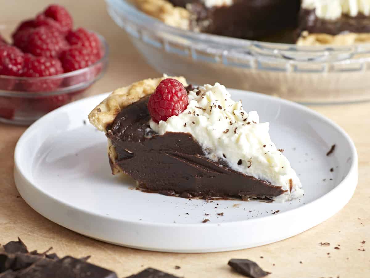 Side view of a slice of chocolate cream pie on a plate. 
