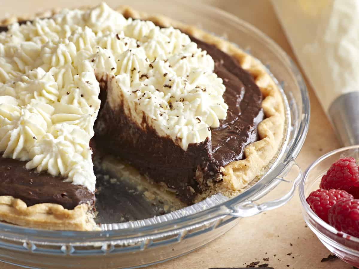 Side view of a chocolate cream pie with a slice removed. 