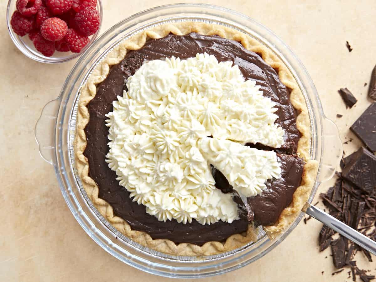 Finished chocolate cream pie with a piece being lifted out. 