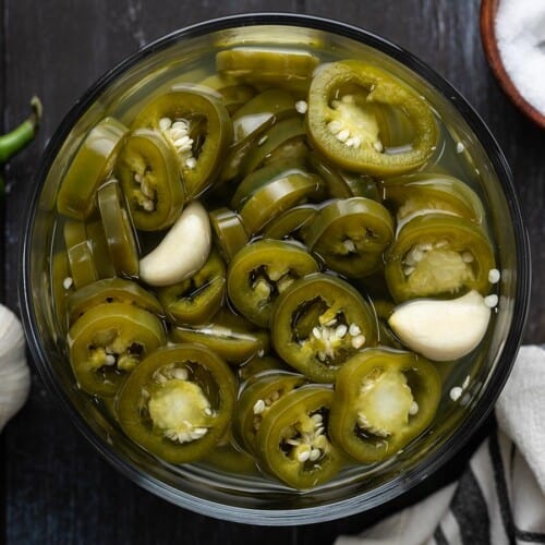 Overhead view of a bowl full of pickled jalapeños.