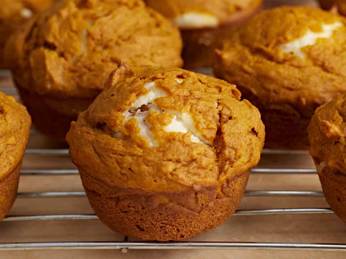 Side view of pumpkin muffins on a wire cooling rack.