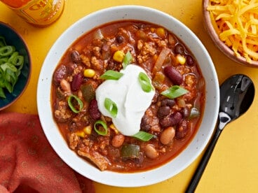 Overhead view of a bowl full of chili with toppings.