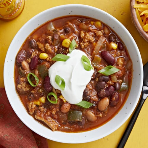 Overhead view of a bowl full of chili with toppings.