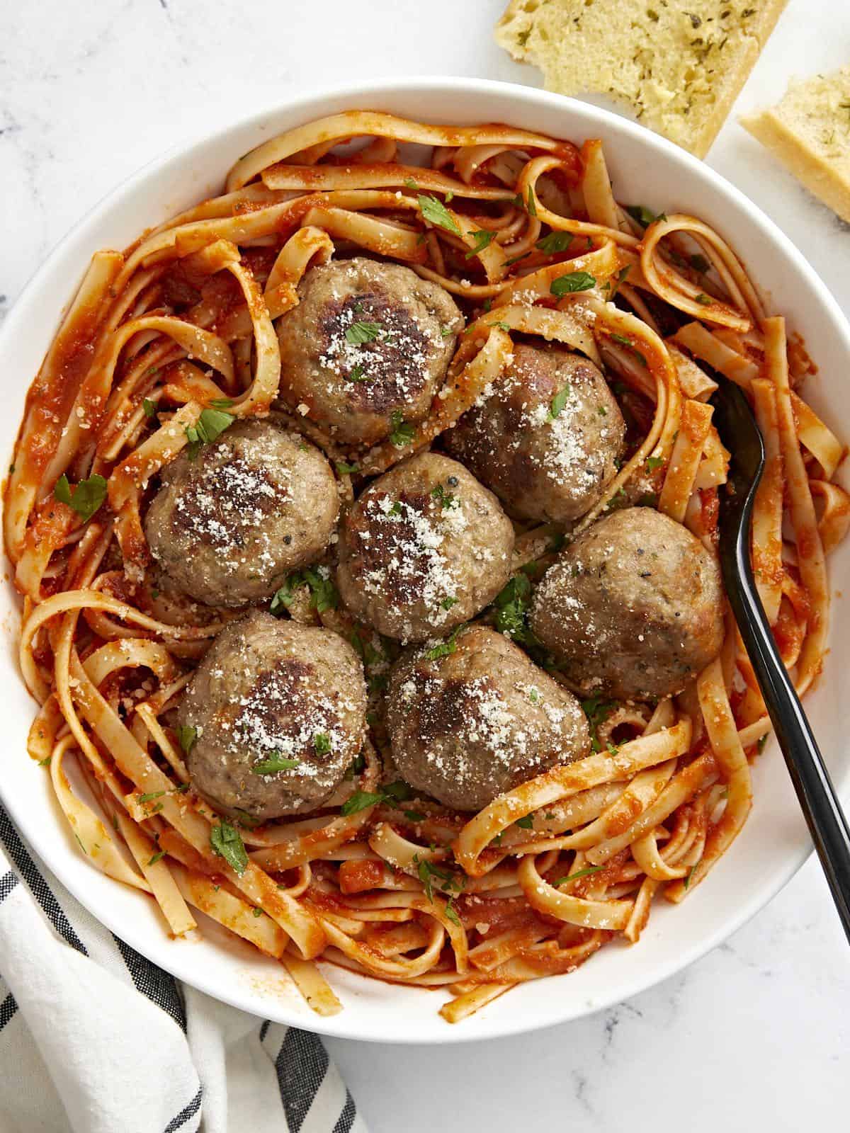 Overhead view of a plate full of spaghetti with turkey meatballs on top.