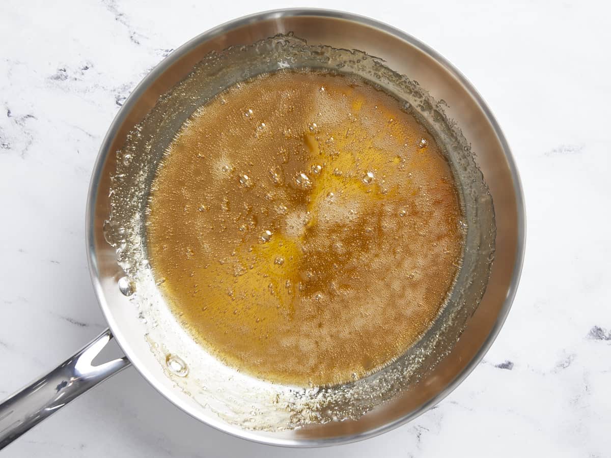 Caramelized sugar and orange juice in a skillet. 