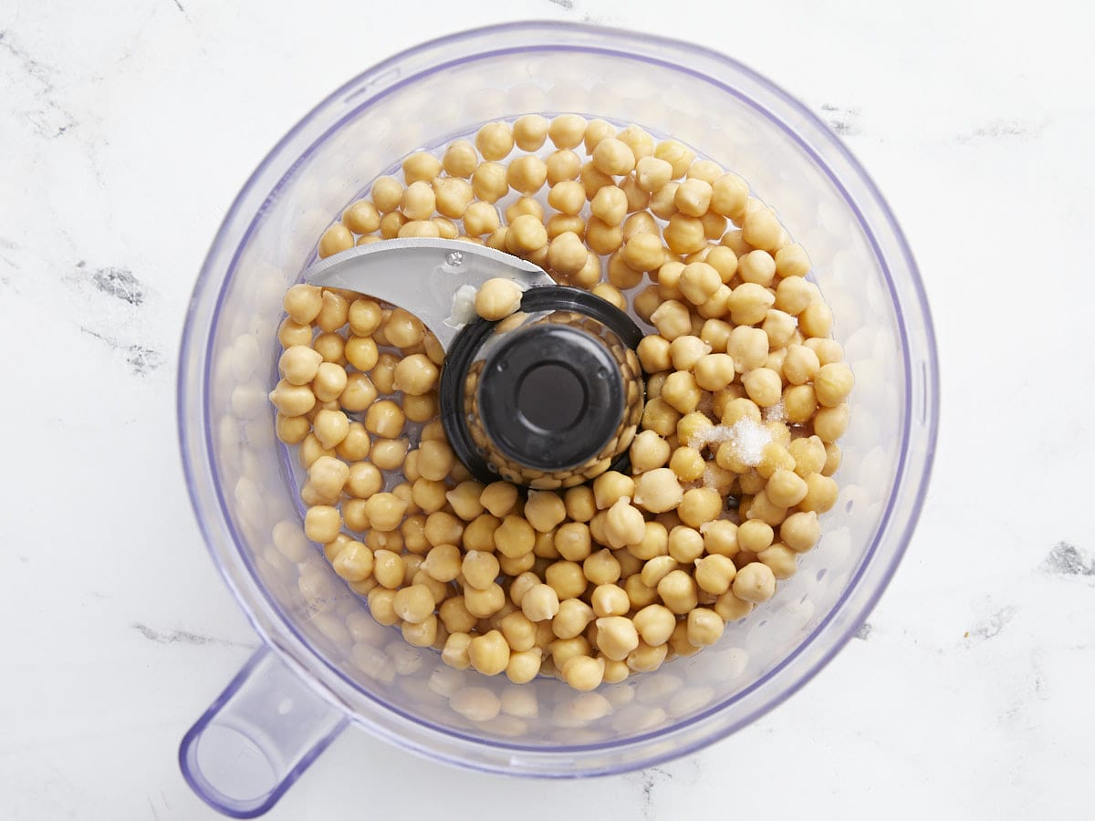 Chickpeas in a food processor with lemon juice, salt, and water. 