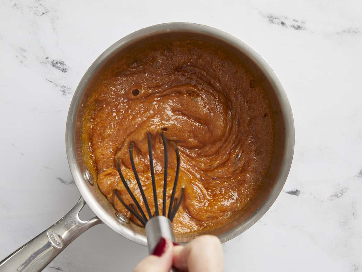 Butter being whisked into the caramelized sugars.