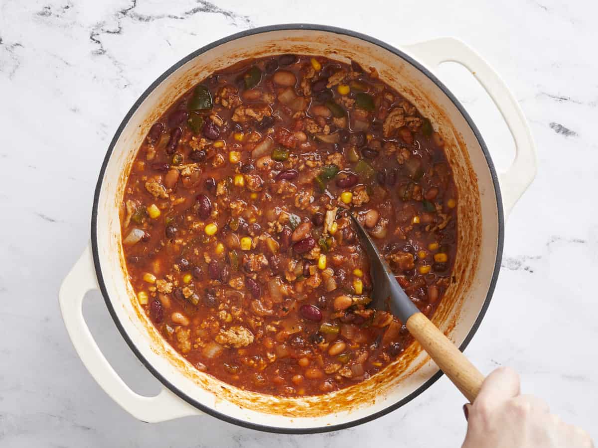 Simmered chili in the pot being stirred.