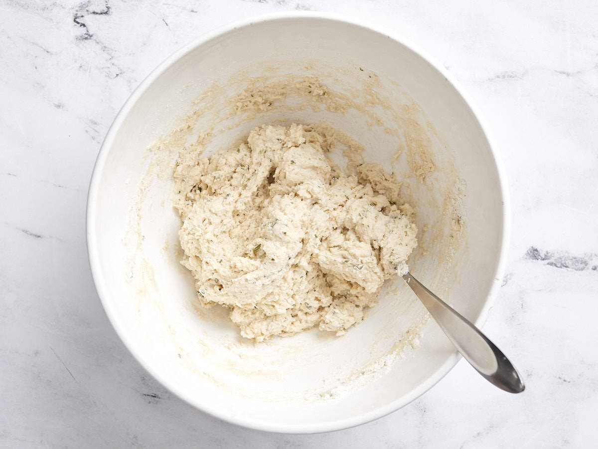 Dumpling dough in a bowl with a spoon.