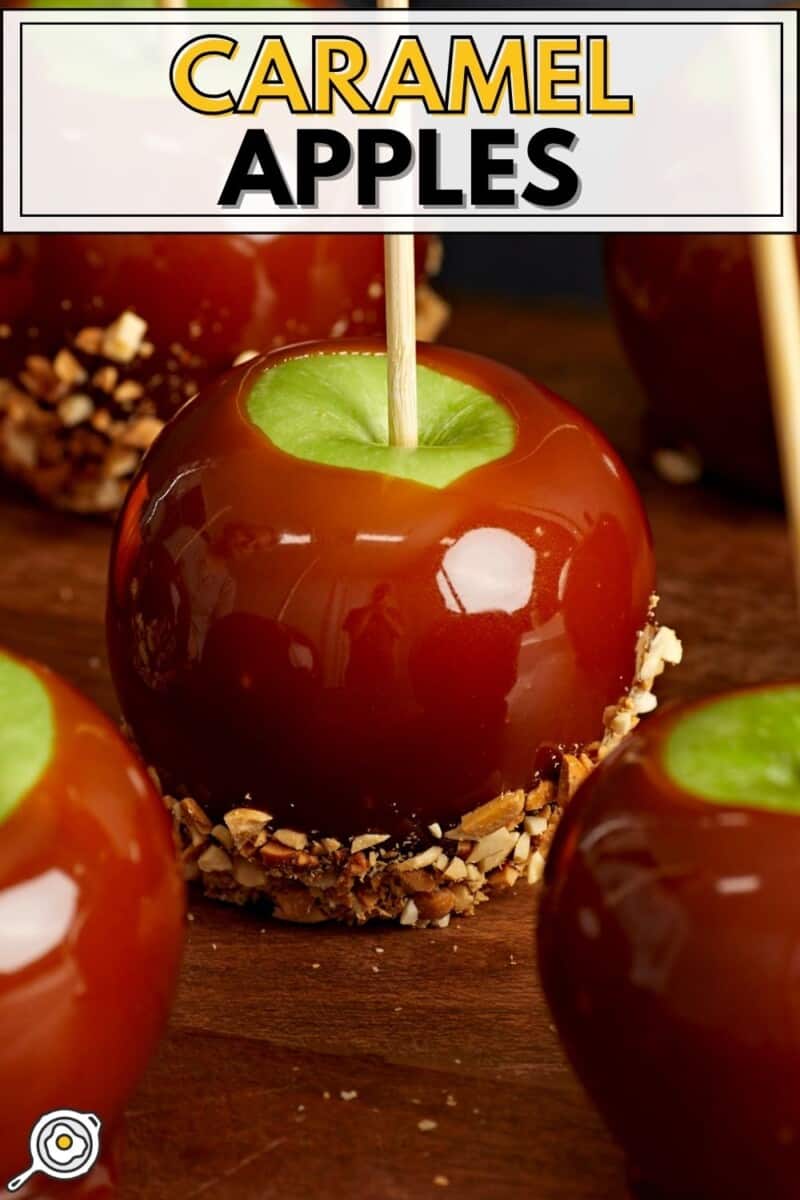 Close up side view of caramel apples on a wooden platter.
