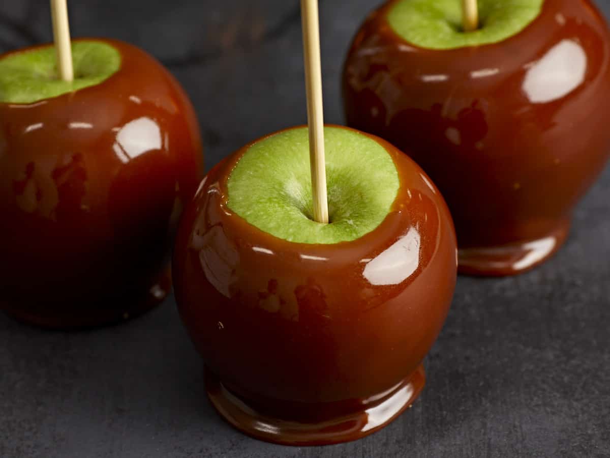 Close up of a caramel apple with two behind it. 