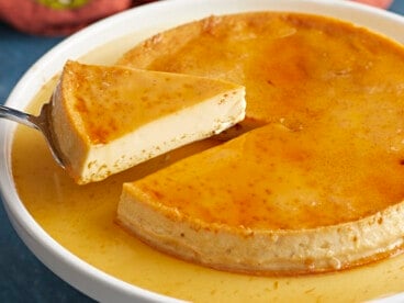 Side view of a piece of flan being lifted from the plate.