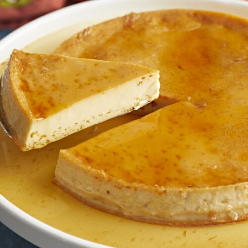 Side view of a piece of flan being lifted from the plate.