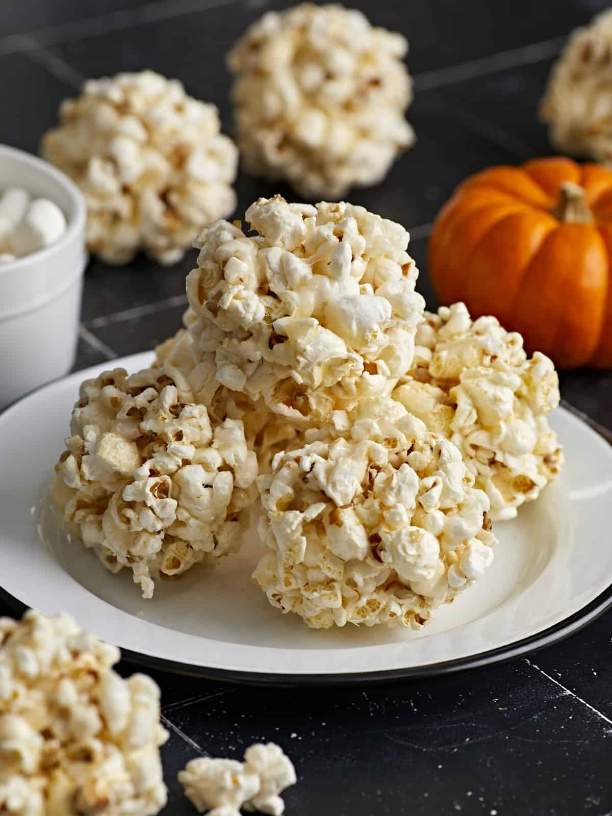 Side view of popcorn balls stacked on top of a plate.