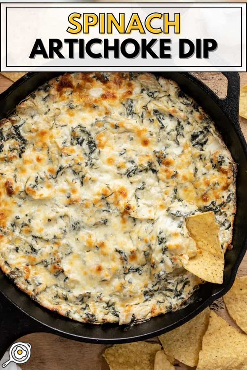 Overhead view of spinach artichoke dip in a skillet with a tortilla chip.
