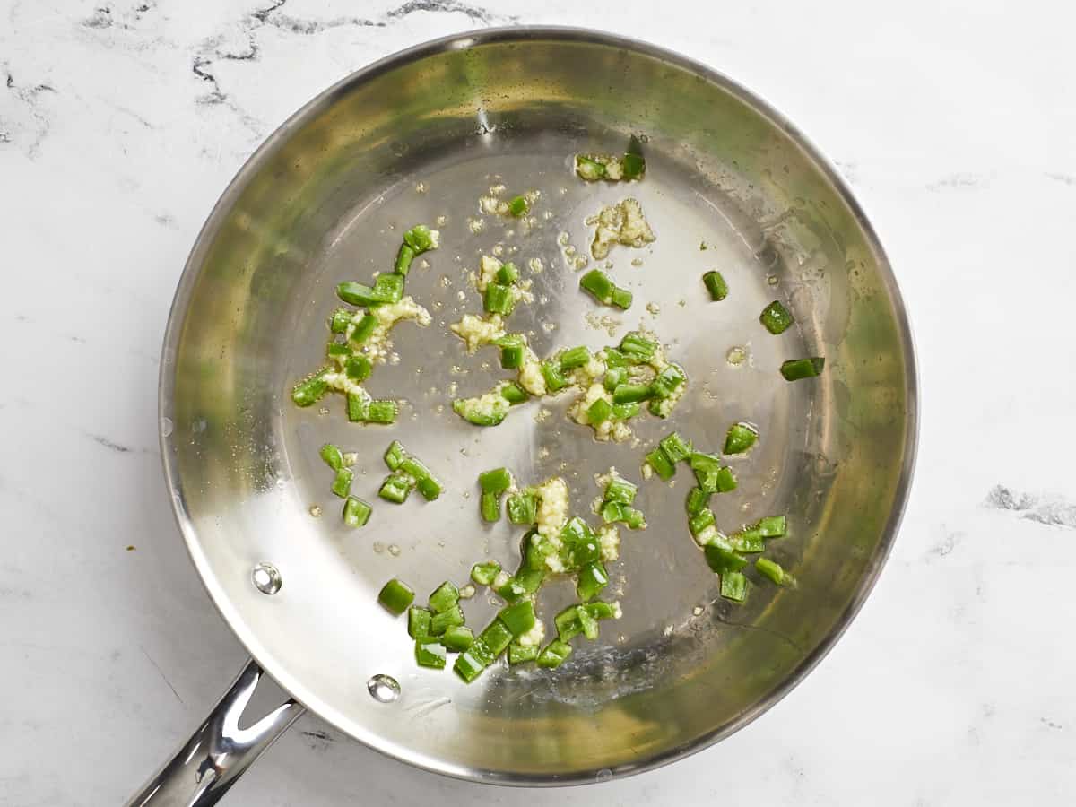 Sautéed garlic and jalapeño in a skillet. 