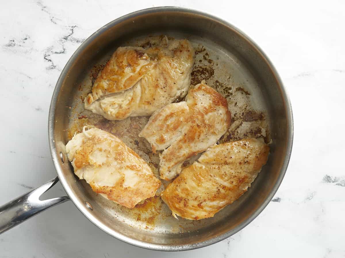 Seared chicken breasts in a skillet.