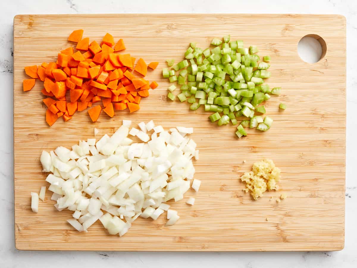 Overhead view of chopped vegetables on a cutting board.