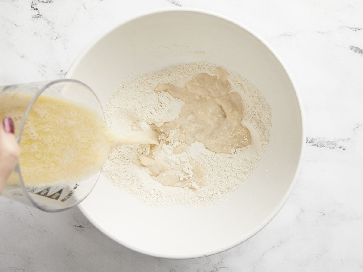 Yeast being poured into a bowl of flour.