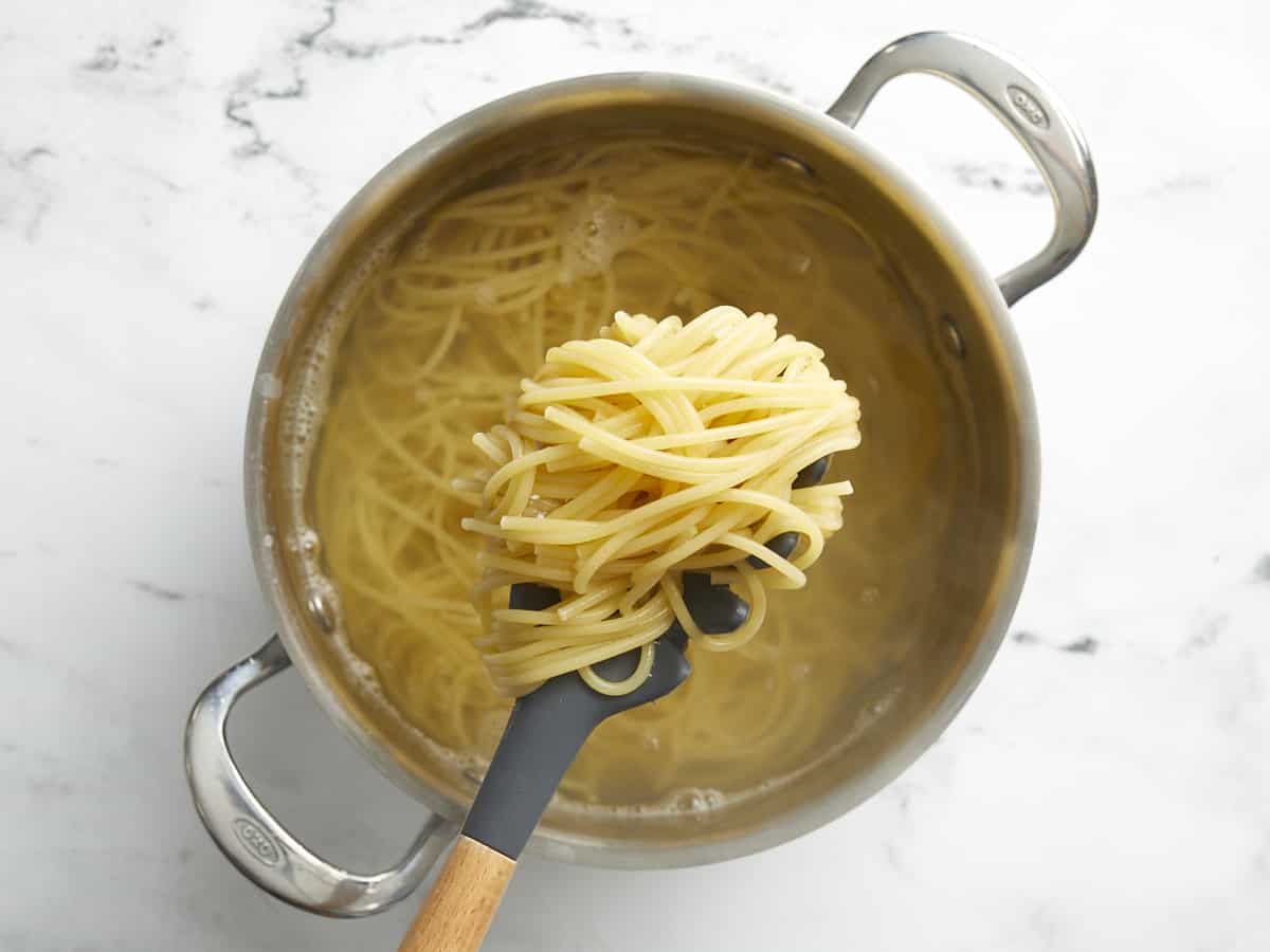 Cooked spaghetti noodles in a pot.