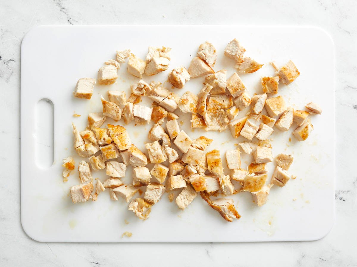 Chicken breasts chopped on a cutting board.