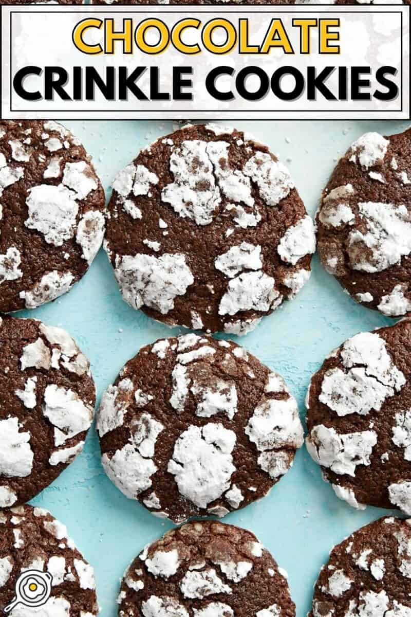 Overhead view of chocolate crinkle cookies lined up on a blue background.
