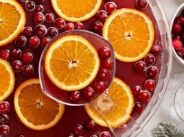 Close up overhead view of a punch bowl full of Christmas Punch with oranges and cranberries.