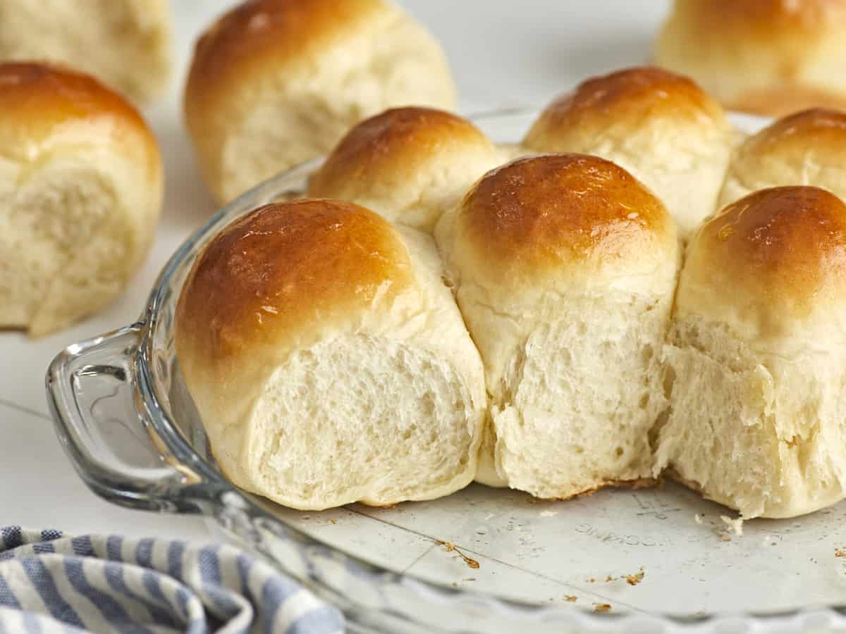 Side view of dinner rolls in the baking dish with a couple rolls removed.