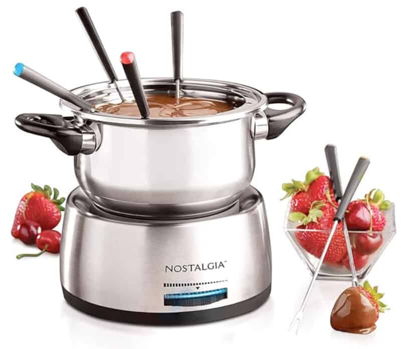 Chrome fondue set showing strawberries dipped in chocolate. 