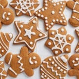 Decorated gingerbread cookies scattered on a white surface.