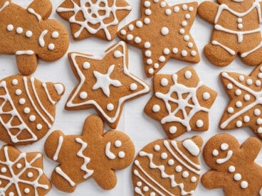 Decorated gingerbread cookies scattered on a white surface.