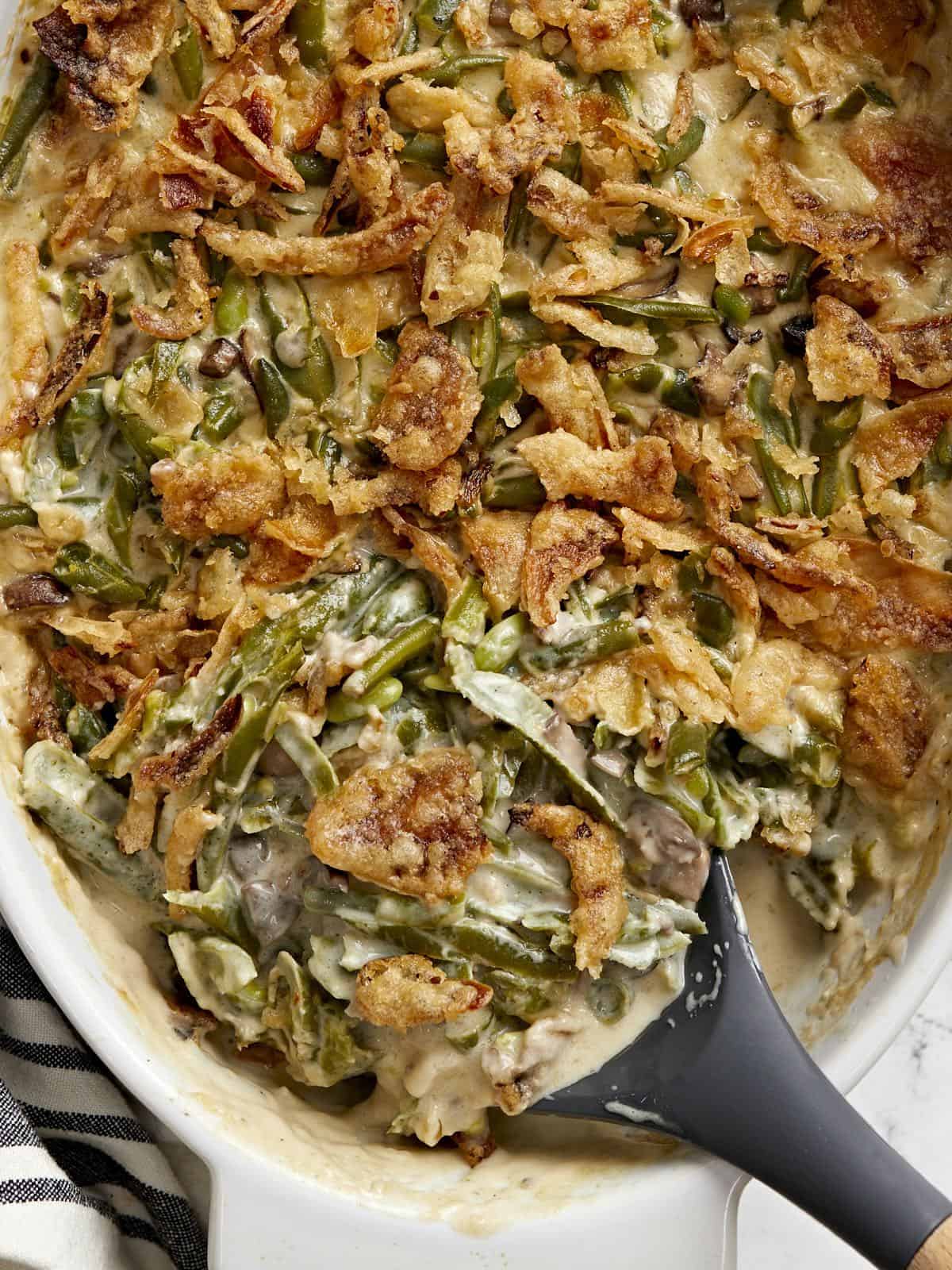 Close up of green bean casserole from above with a spoon scooping it out.