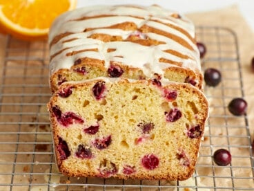 Front view of a sliced loaf of orange cranberry bread.