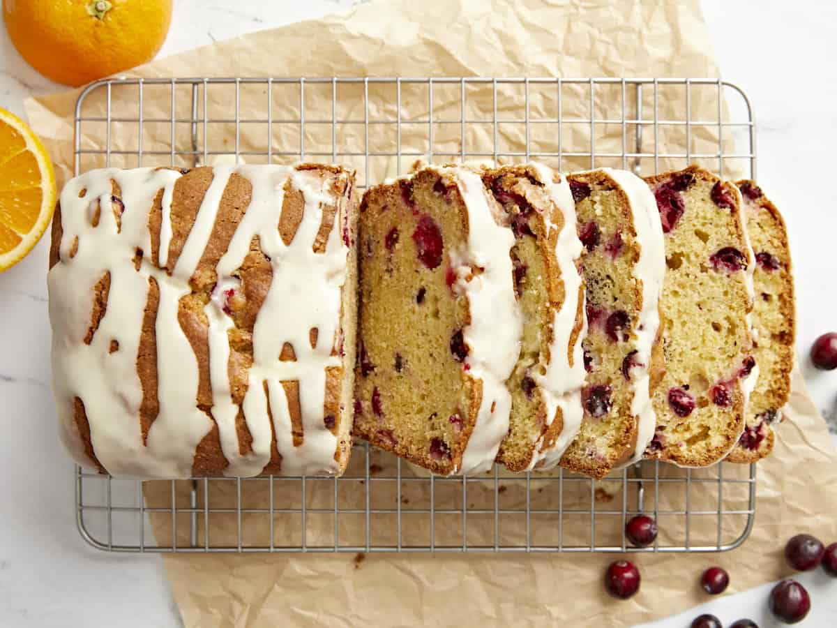 Overhead view of sliced cranberry orange bread on a cooling rack. 