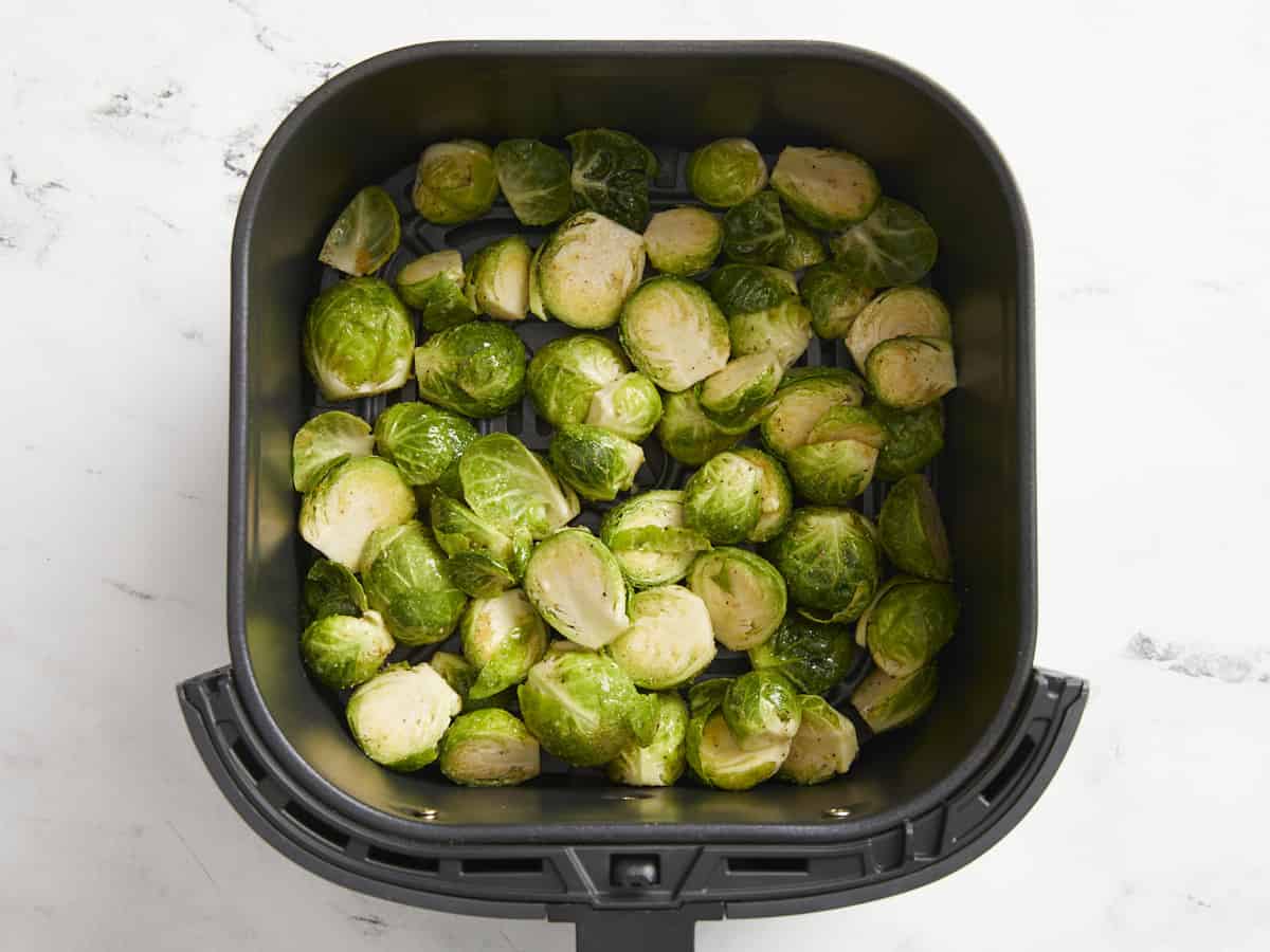 Seasoned and pre-cooked Brussels sprouts in the air fryer.