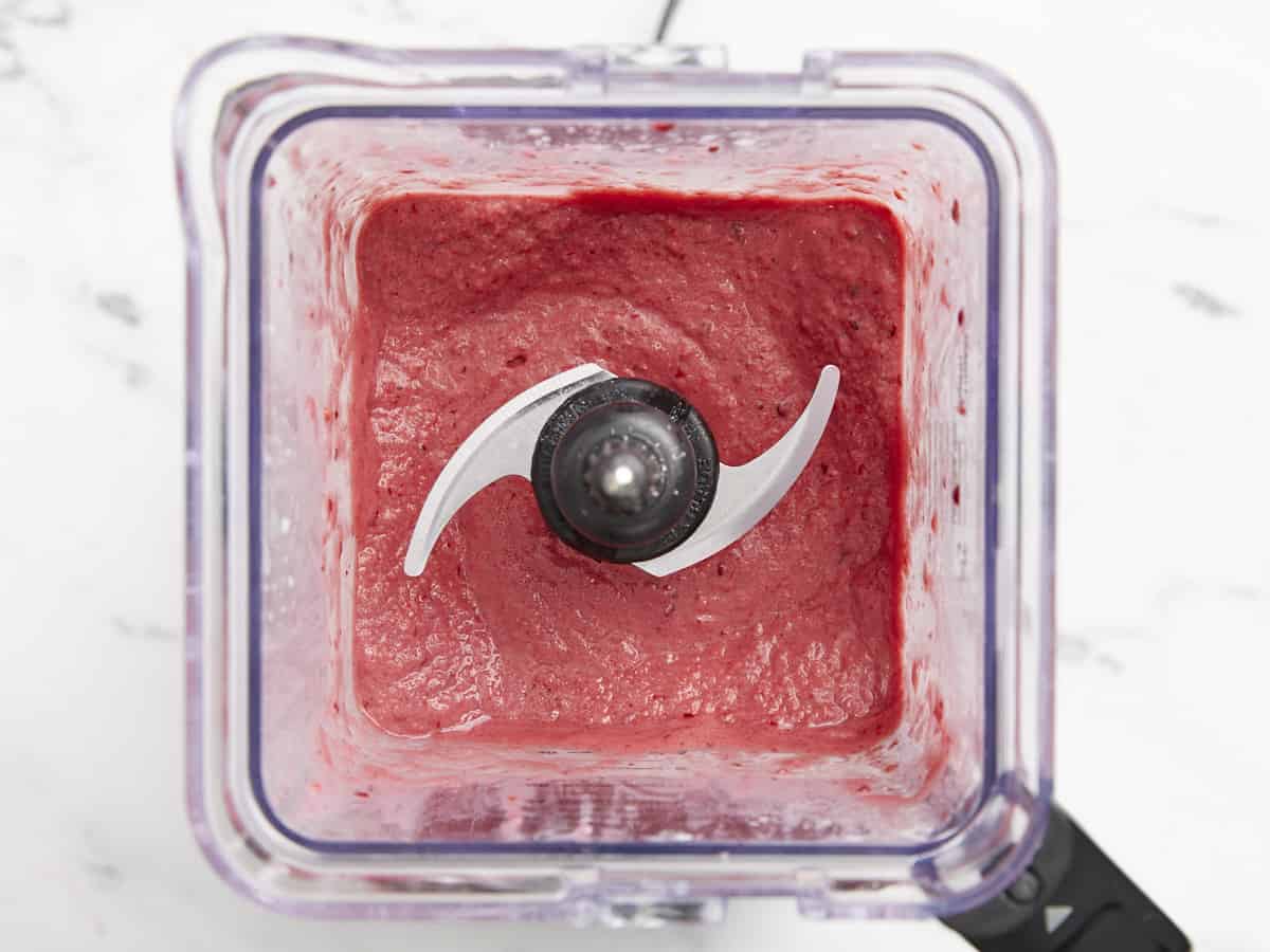 Overhead view of mixed berry smoothie fully blended inside the blender container.