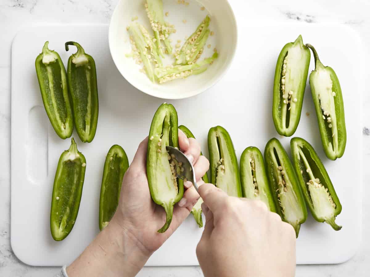 Scraping out the insides of the jalapeño peppers.
