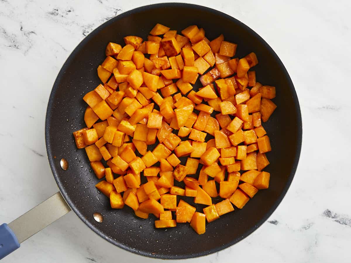 Diced and cooked sweet potatoes in a nonstick skillet.