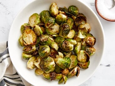 Overhead view of air fryer brussels sprouts in a white serving dish.