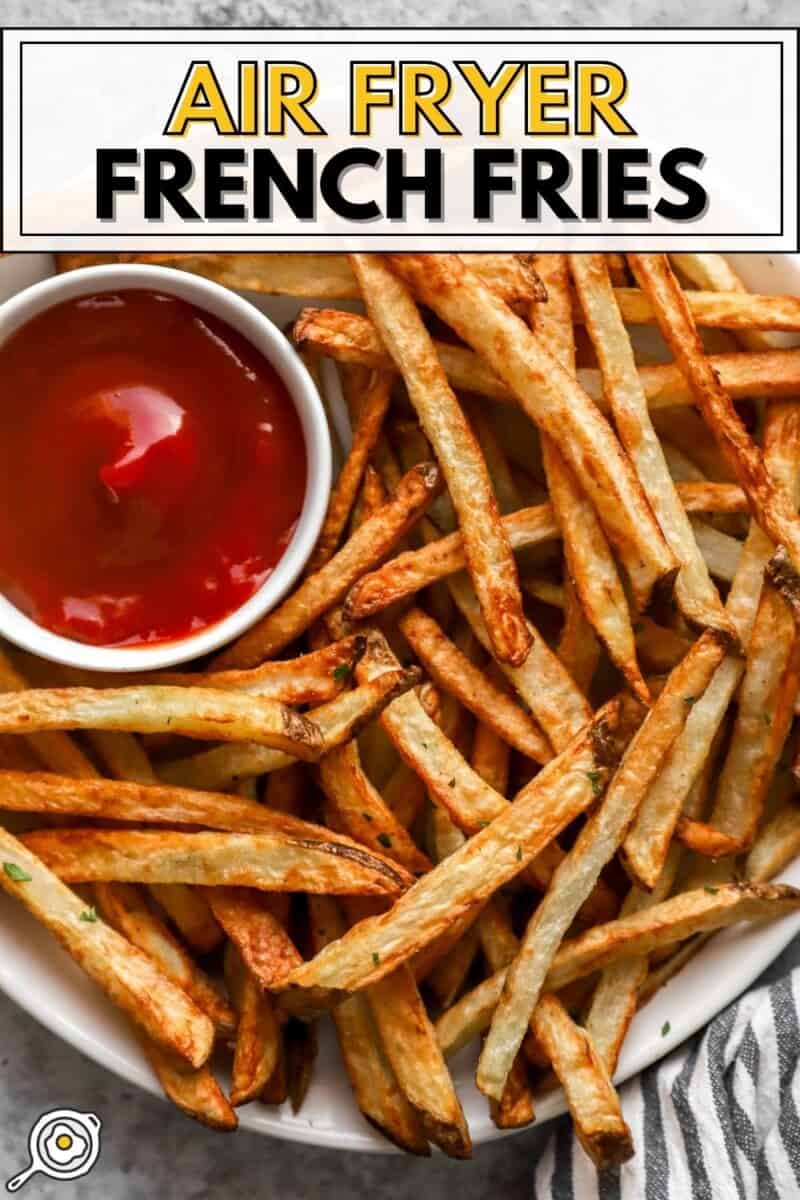 overhead view of air fryer french fries on a white plate with ketchup and title text at the top.