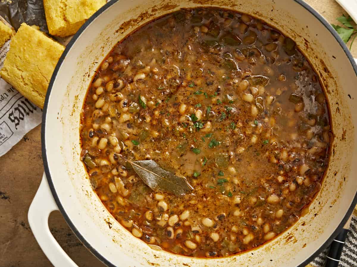 Close up overhead view of a pot of black eyed peas with a bay leaf.
