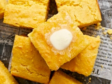 Close up overhead view of squares of cornbread with butter melting top.