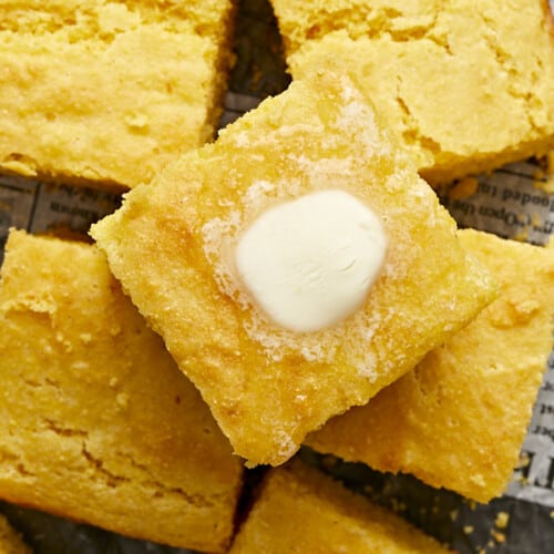 Close up overhead view of squares of cornbread with butter melting top.