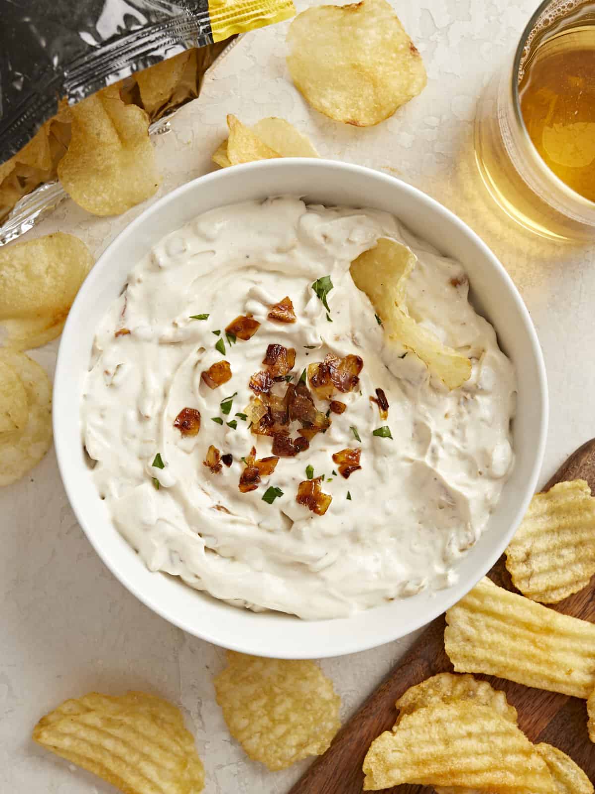 Overhead view of a bowl of French Onion Dip with a chip in the side and chips all around.