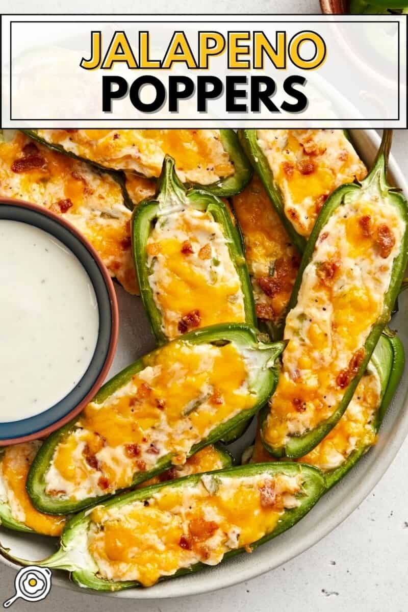 Close up overhead view of jalapeño poppers on a plate with a bowl of ranch.