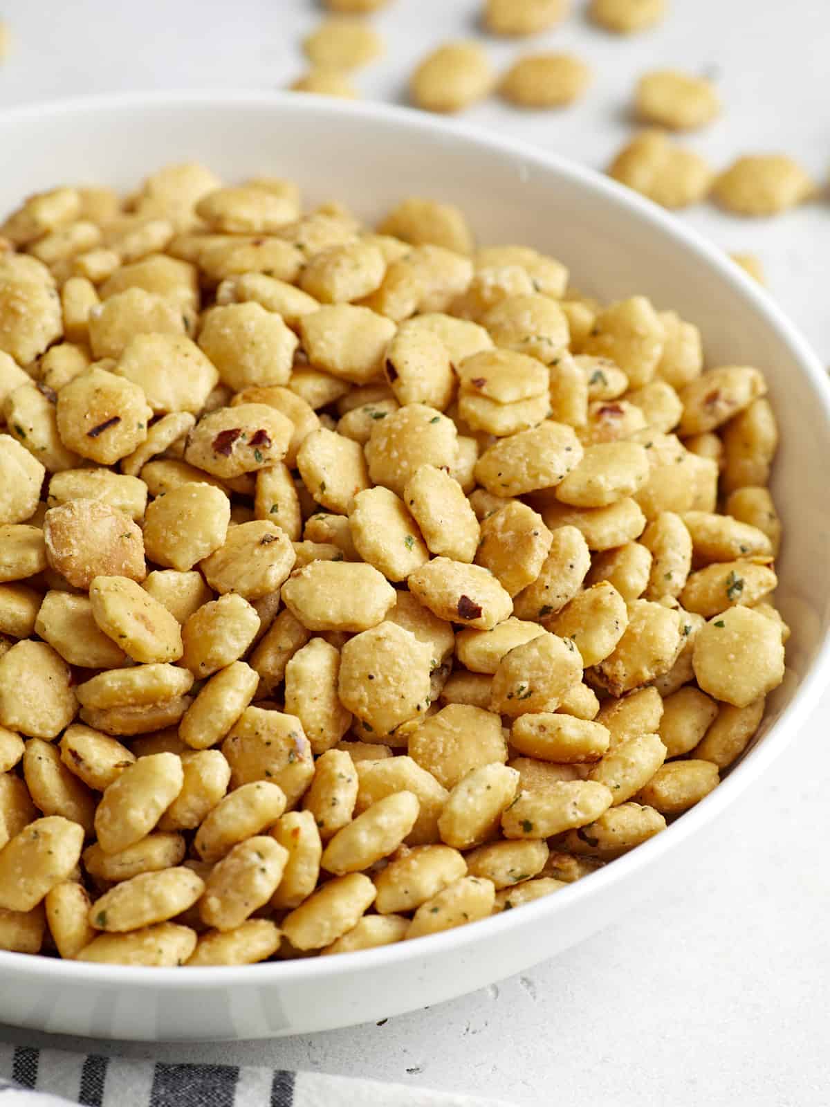 Side close up view of ranch oyster crackers in a white serving dish.