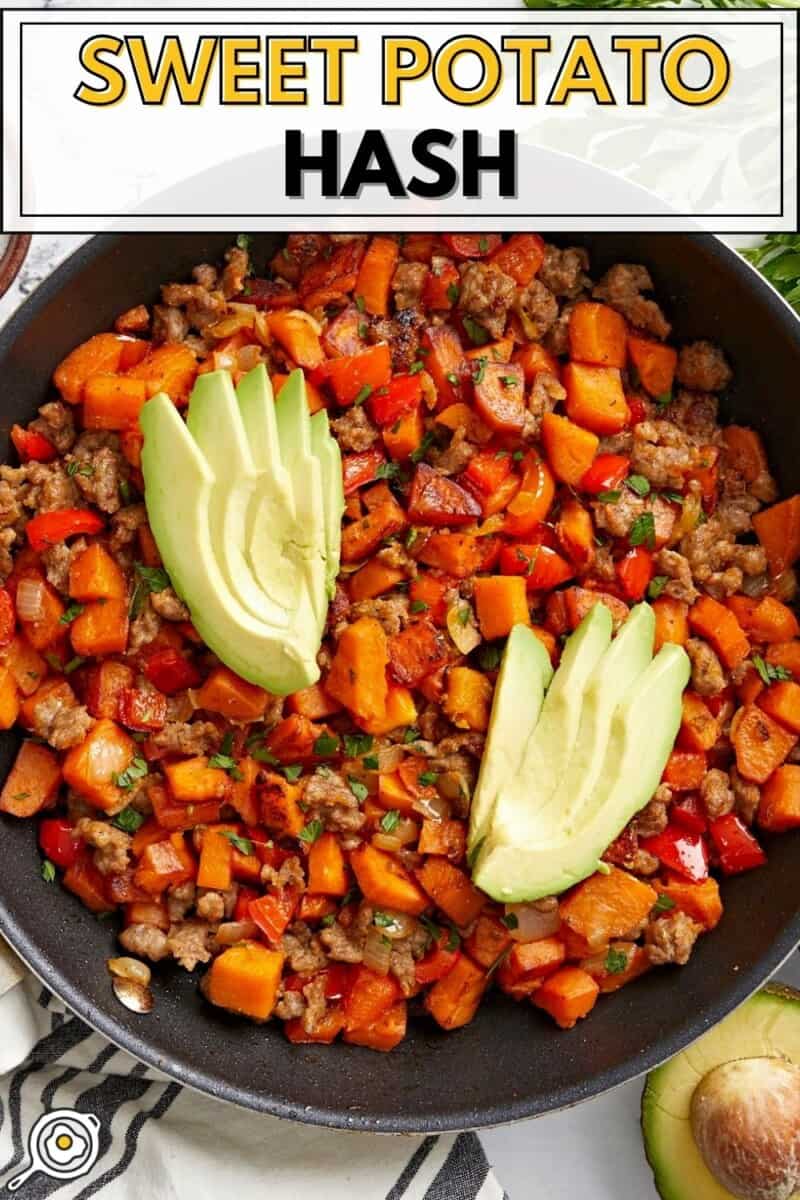 Overhead view of sweet potato hash in a skillet garnished with sliced avocado.